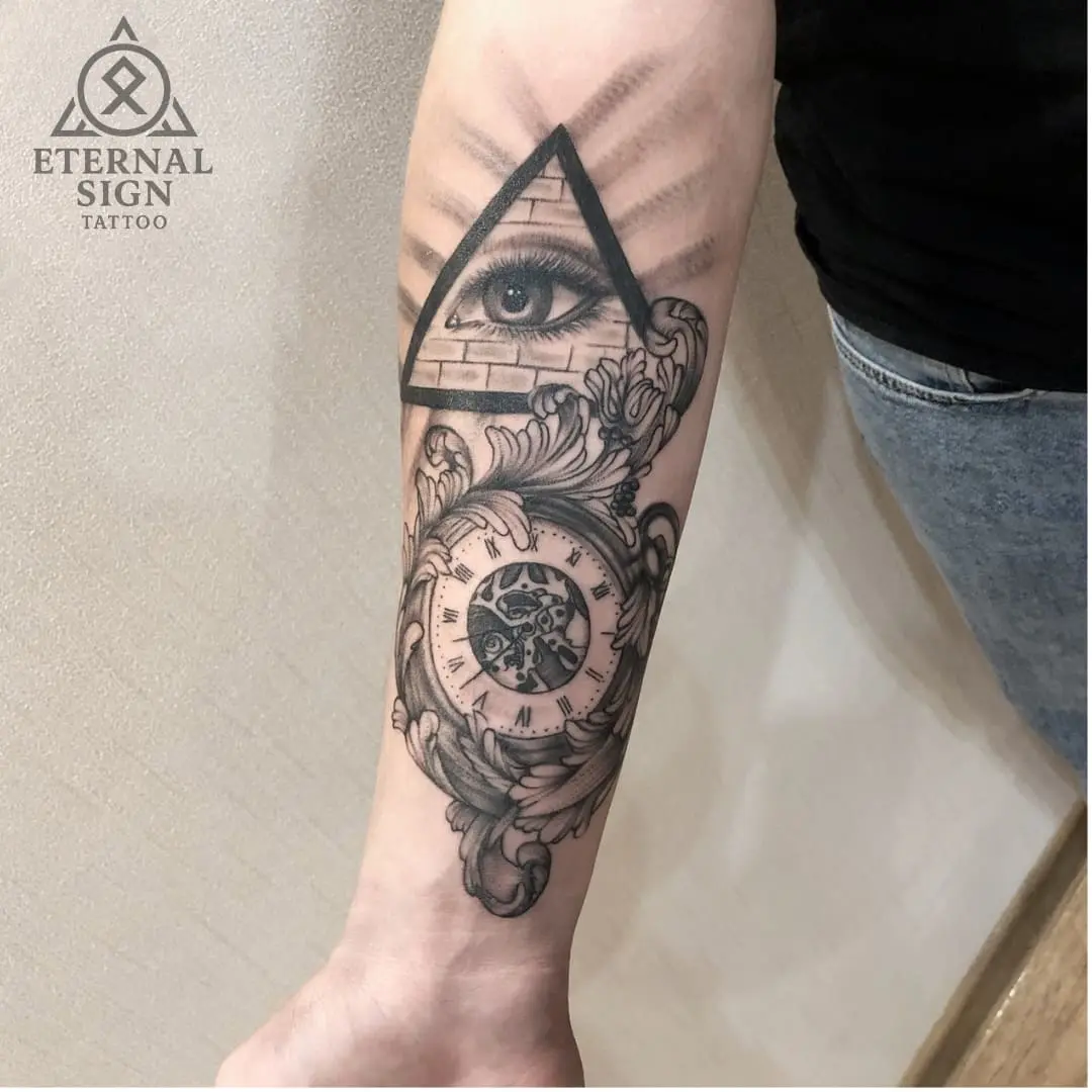 Svart-hvitt realistisk tattoo med øye og klokke på underarmen i Fredrikstad