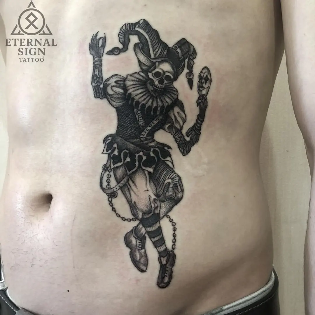 Svart-hvitt tatovering av demonisk figur på magen i Fredrikstad