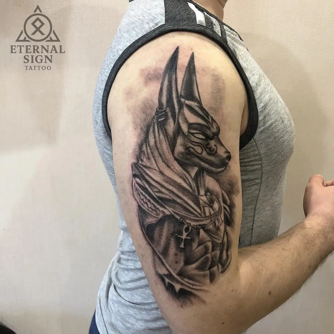 Svart-hvitt tatovering av Anubis på overarmen i Fredrikstad