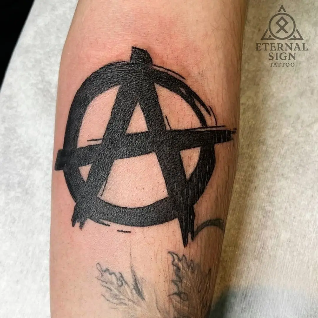 Svart anarkist-symbol tatovering på underarmen i Østfold