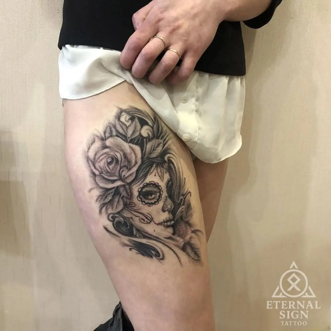Svart-hvitt tatovering av sugar skull med roser på låret i Østfold