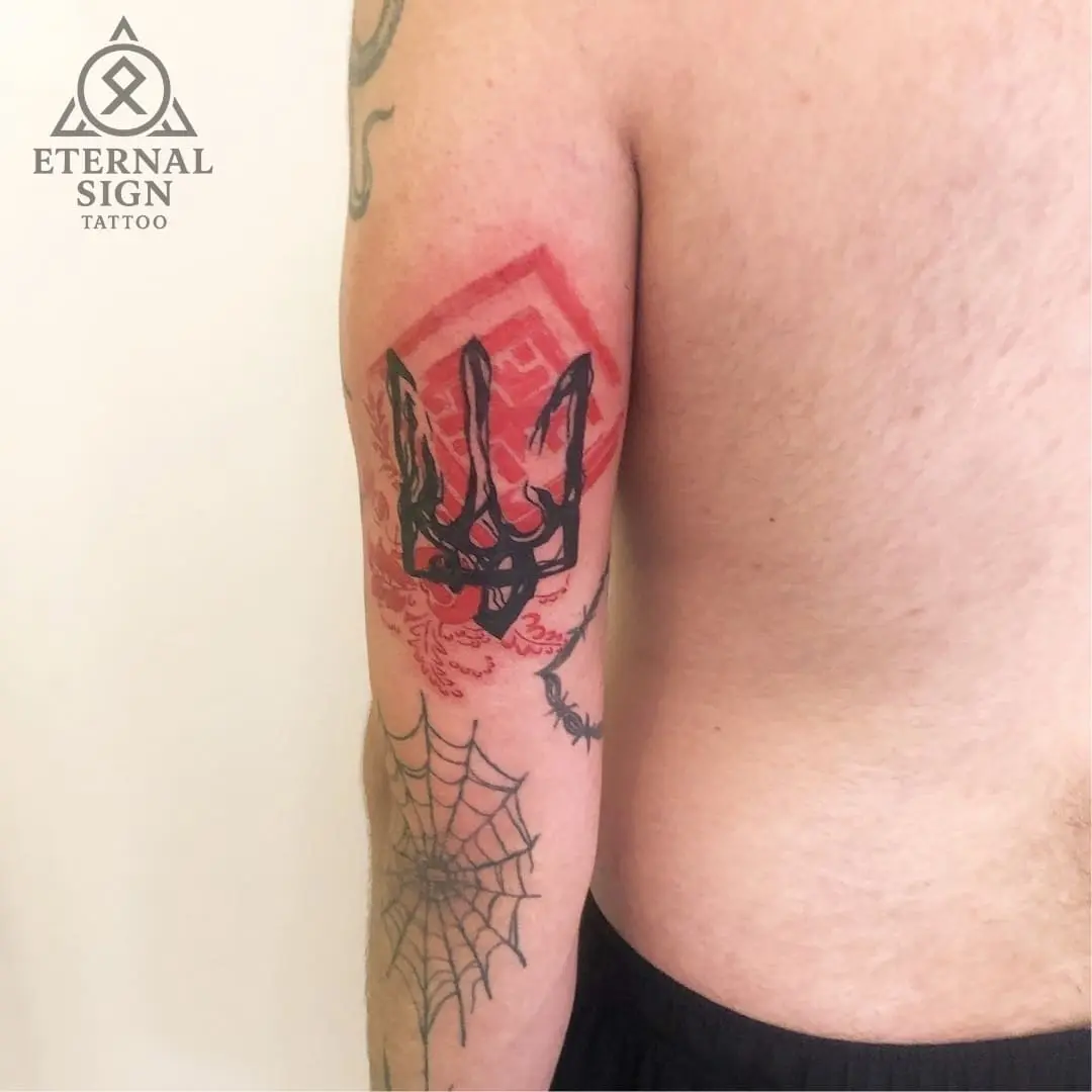 Farget tatovering av trident og edderkoppnett på biceps i Fredrikstad